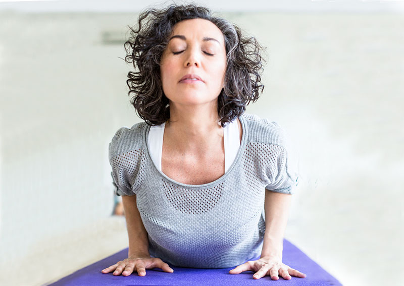 woman doing yoga neck move after having cervical disc replacement with dr. neil cochrane