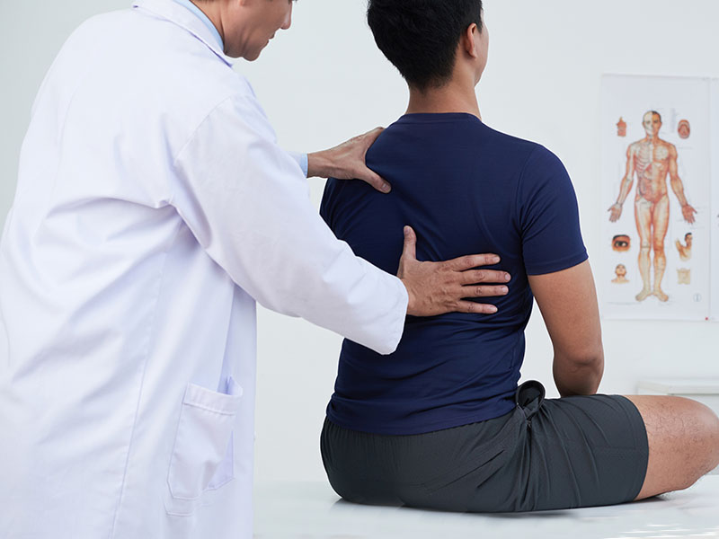 dr. neil cochrane examines a patient as part of his treatment philosophy of conservative care